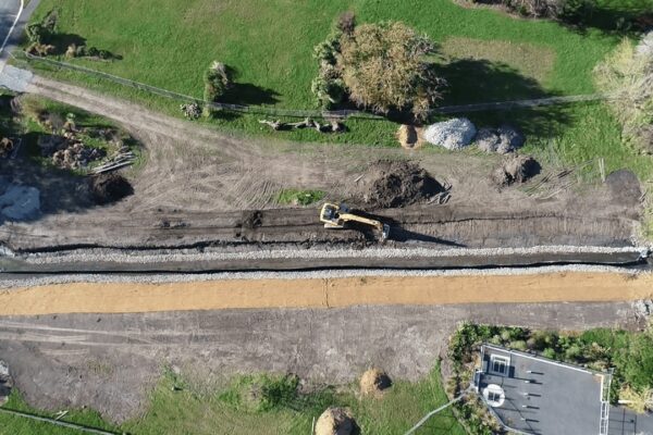Aerial view of storm drain and stormwater drainage system upgrades with civil contractors completing deep drainage, land excavation, and storm water solutions as part of local earthworks regeneration work.