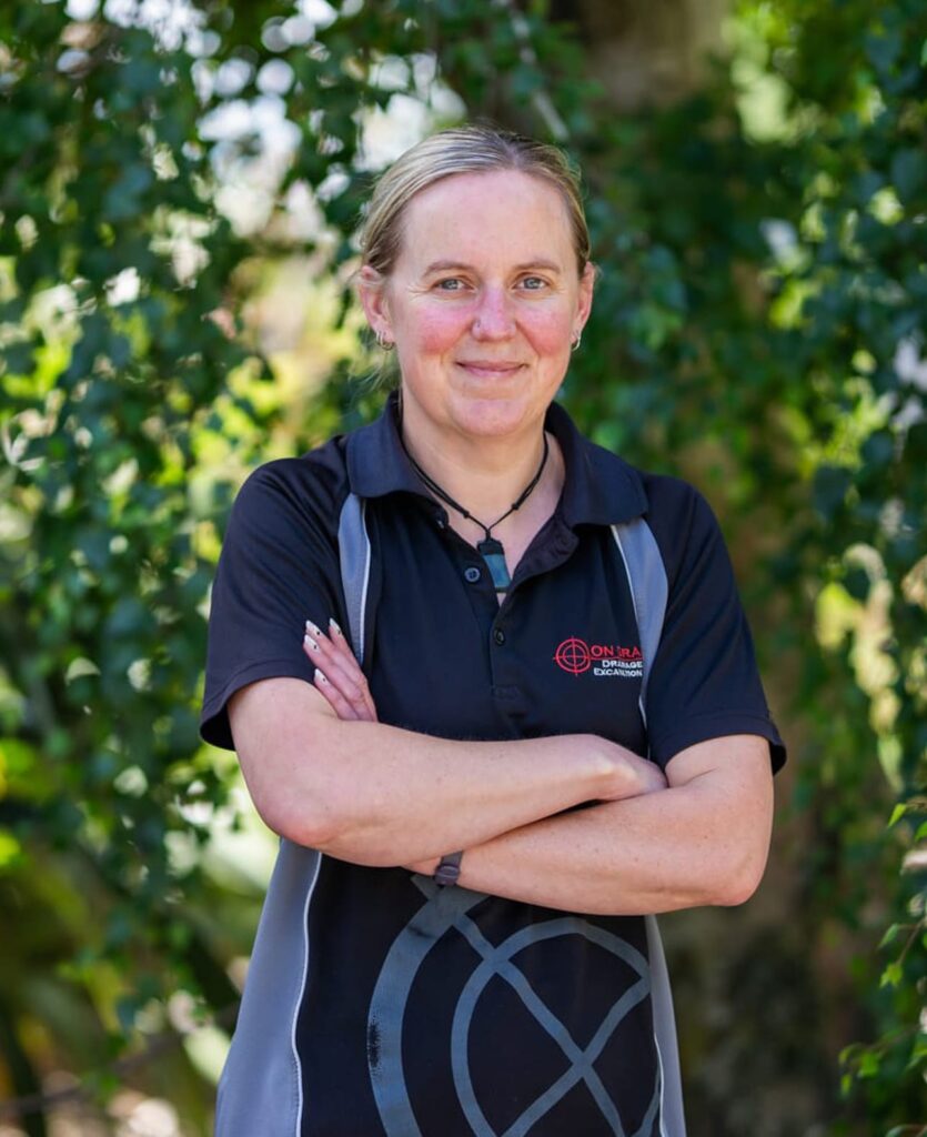 Team member in company uniform outdoors representing civil engineering company services including water reticulation, wastewater treatment systems, stormwater drainage, kerb and channel work, subdivision earthworks and local earthworks.