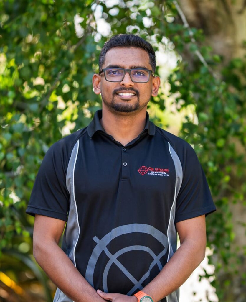 Team member in company uniform standing on site, reflecting civil work, storm water solutions, sanitary sewer pump stations, wastewater treatment system support, subdivision earthworks and construction contractor services.