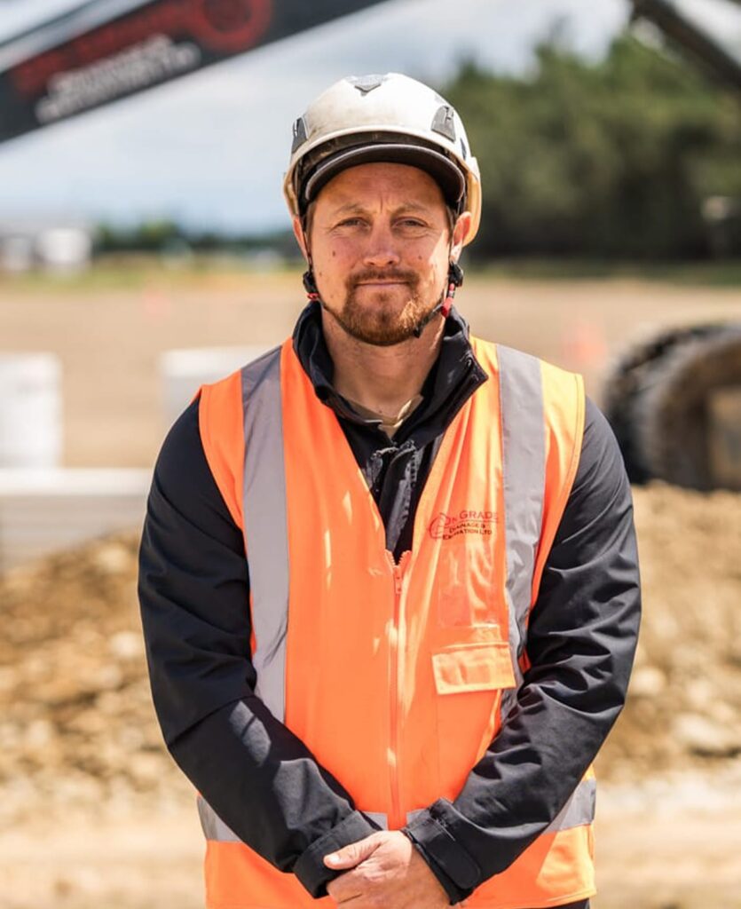 Construction worker on site wearing high-vis and safety helmet, representing contractor company services including storm water solutions, wastewater treatment, civil construction, deep drainage, water reticulation and blocked storm water drain repairs.