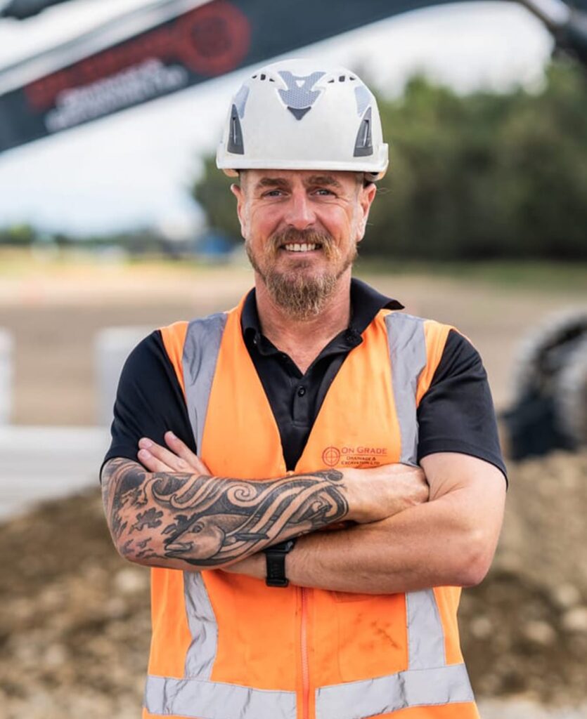 onstruction contractor wearing high-vis and helmet on a civil construction site, demonstrating sewage treatment plant support, stormwater drainage, deep drainage, water treatment plants, wastewater treatment system work and land excavation.
